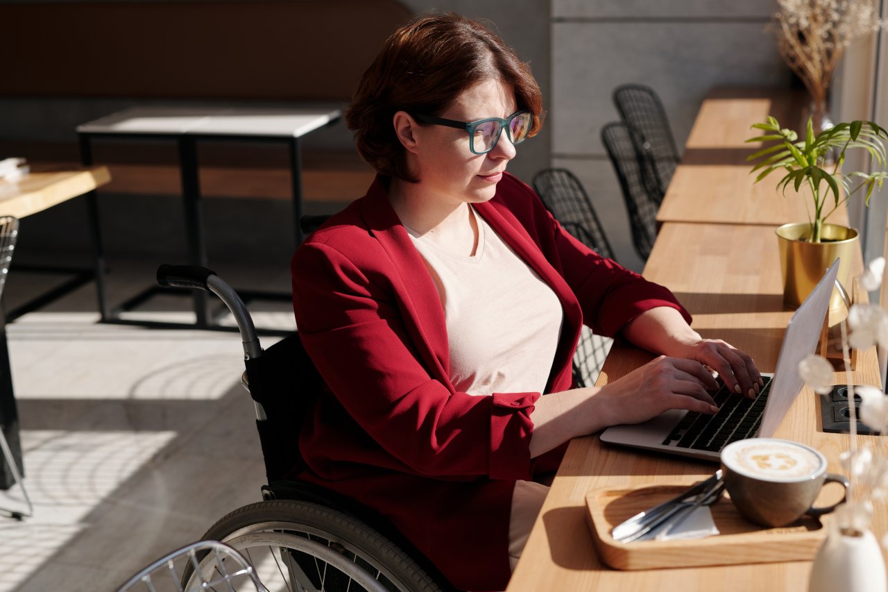 Woman using Laptop in Cafe.